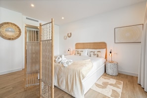 A bedroom with a bed, a bedside lamp, a round mirror, and a woven partition. - Elegant 4-Pax Apartment in Casares (Casares)