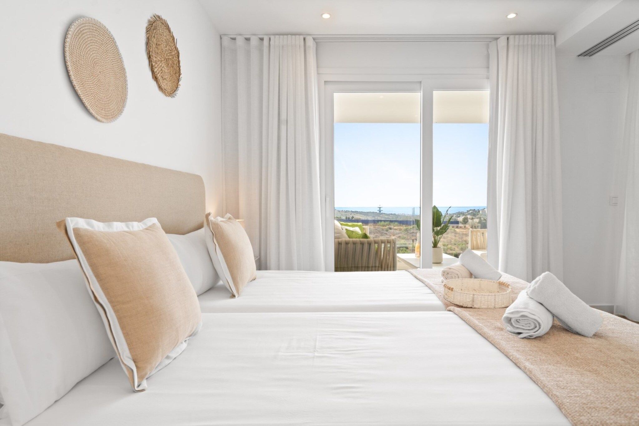 Une chambre d’hôtel avec deux lits, un balcon avec vue et une grande fenêtre.