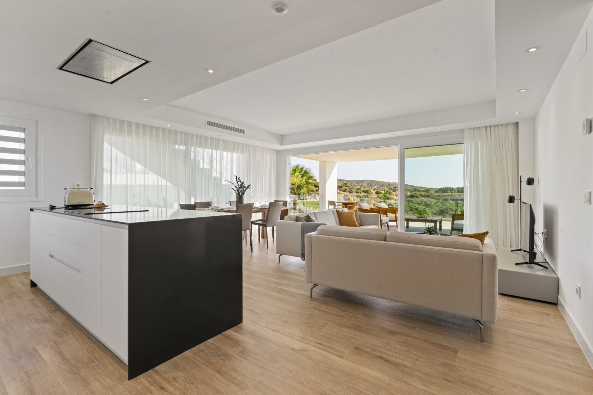 Un espace de vie moderne comprenant une cuisine, un coin repas et un salon avec vue.