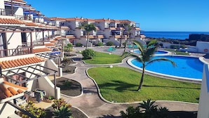 Ein Resort mit mehreren Gebäuden, einem Schwimmbad und Blick auf den Ozean.