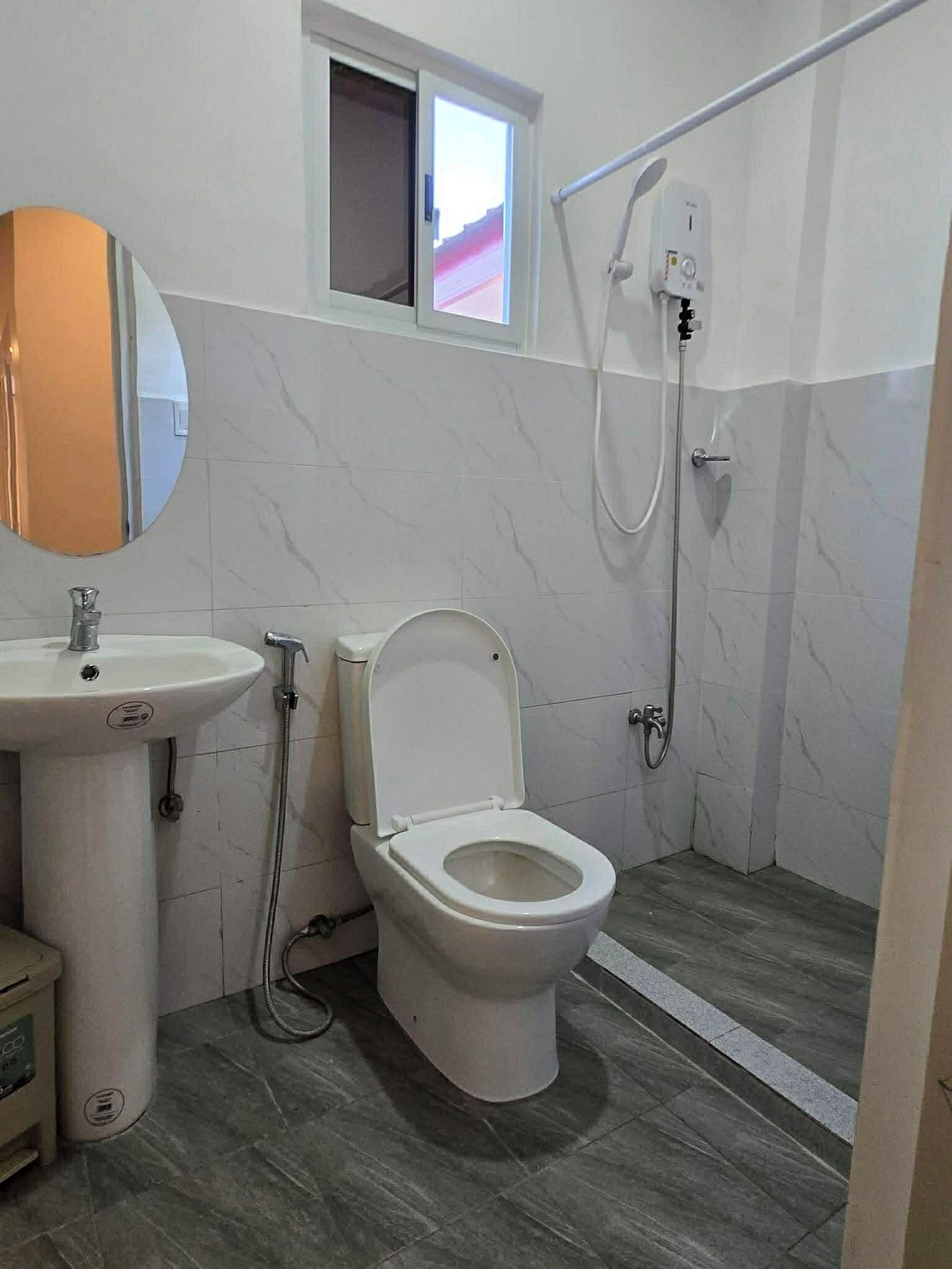 Un baño con inodoro, lavamanos y ducha.