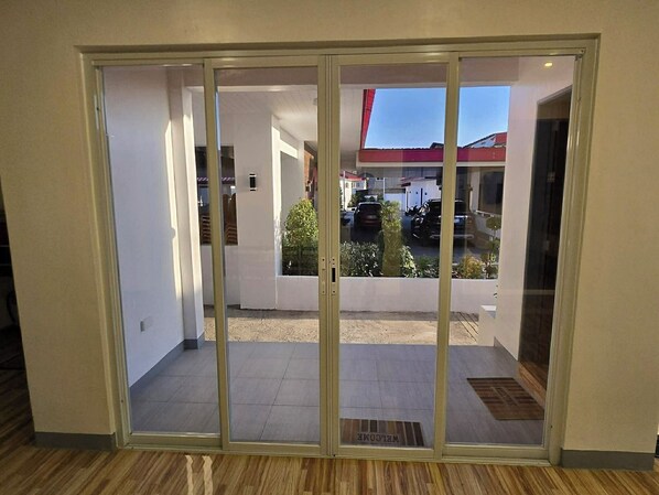 A modern interior with a sliding glass door leading to an outdoor area. - Kangaroo Hill Pavilion and Resort (Bayambang)