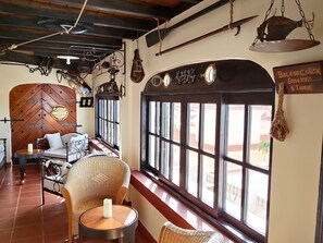 A cozy room with a wooden door, wicker furniture, and a window with a view.