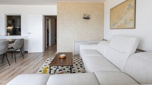 A modern living room with a grey sofa, a wooden coffee table, and a patterned rug. - 3 bedroom accommodation in Nieuwpoort (Nieuwpoort)