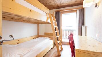 Une chambre avec un lit superposé, une échelle en bois, un bureau et une chaise.