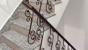 A staircase with granite steps and ornate metal railings. - The Vow Cartel Ananta (Varanasi)
