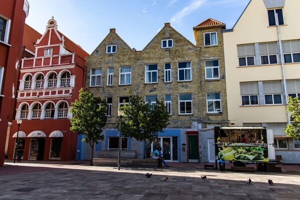 Eine Straße mit Gebäuden, einer Straßenlaterne und einem Essensstand.