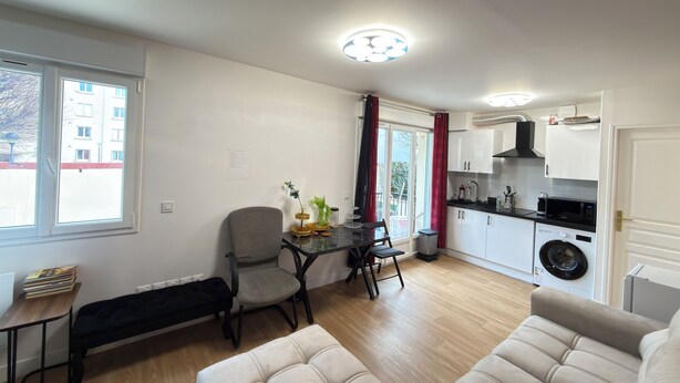 A compact living space with a dining area, kitchenette, and seating area. - Royal Rose Apartment With Royal Garden (Le Bourget)