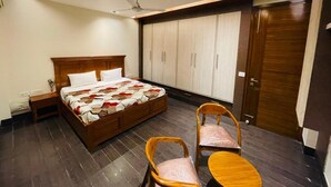 Een slaapkamer met een bed, houten nachtkastjes, een plafondventilator en een garderobe.