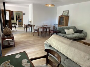 A living room with a sofa, chairs, a dining table, and a card game setup. - Country house with swimming pool near the most beautiful villages in France (Marcillac-la-Croze)