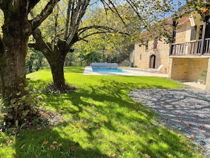 A stone building with a swimming pool, surrounded by a grassy lawn and trees. - Country house with swimming pool near the most beautiful villages in France (Marcillac-la-Croze)