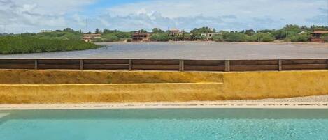 A swimming pool with a clear view of the surrounding landscape, including a distant building and greenery.