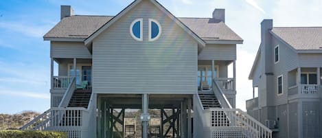 A two-story house with a central entrance, a covered porch, and a staircase leading to the upper floor.
