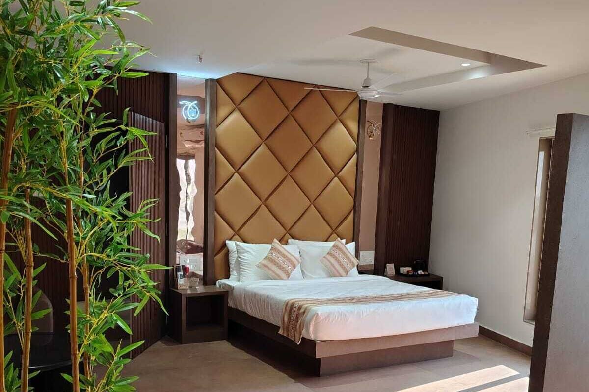 Ein modernes Schlafzimmer mit einem Bett, einem Nachttisch, einem großen Fenster und einer Zimmerpflanze.