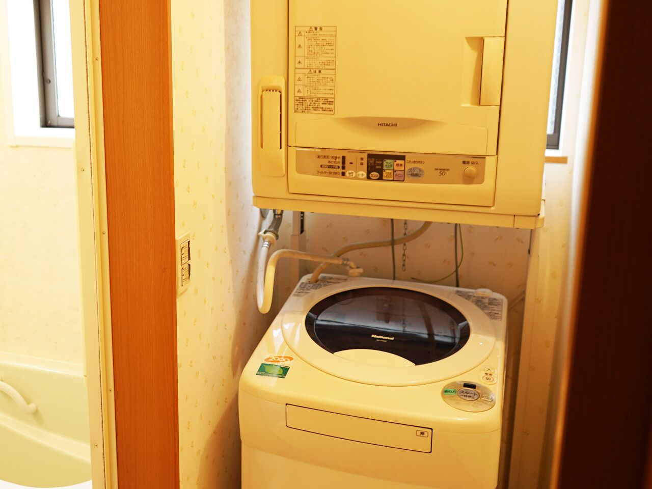 A compact, single-room layout with a washing machine and a small cabinet above it.