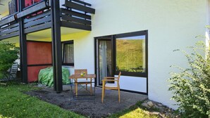 A balcony with a wooden railing, a table with chairs, and a covered area. - "Chalet Imberg", Oberstaufen-Steibis (Oberstaufen)