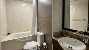 A modern bathroom with a bathtub, toilet, and sink. - Silkhaus Premium 1bdr in Dubai Production City (Dubai)