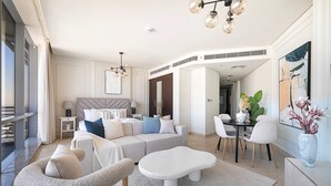 Ein modernes Wohnzimmer mit Sofa, Couchtisch und Essbereich mit Stühlen.