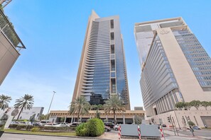 A tall building with a modern design, featuring a prominent vertical element and a large glass facade. - Silkhaus Comfy Studio in Sky Gardens Difc Views (Dubai)