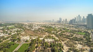 An aerial view of a cityscape with modern high-rise buildings, green spaces, and a mix of residential and commercial areas. - Silkhaus Comfy Studio in Sky Gardens Difc Views (Dubai)