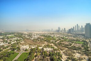 An aerial view of a cityscape with modern high-rise buildings, green spaces, and a mix of residential and commercial areas. - Silkhaus Comfy Studio in Sky Gardens Difc Views (Dubai)