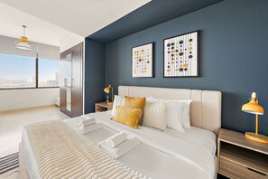 A modern hotel room with a large bed, a nightstand with a lamp, and artwork on the wall. - Silkhaus Comfy Studio in Sky Gardens Difc Views (Dubai)
