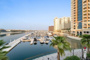 A marina with multiple boats docked, surrounded by high-rise buildings and palm trees. - Silkhaus Beach Accessible Studio Palm View (Dubai)