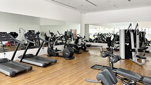 A spacious gym with multiple treadmills, elliptical machines, and weight equipment. - Silkhaus Luxury Studio Nova Tower High Floor (Dubai)