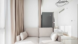 A modern living room with a beige sofa, a wooden coffee table, and a minimalist design. - Silkhaus Luxury Studio Nova Tower High Floor (Dubai)