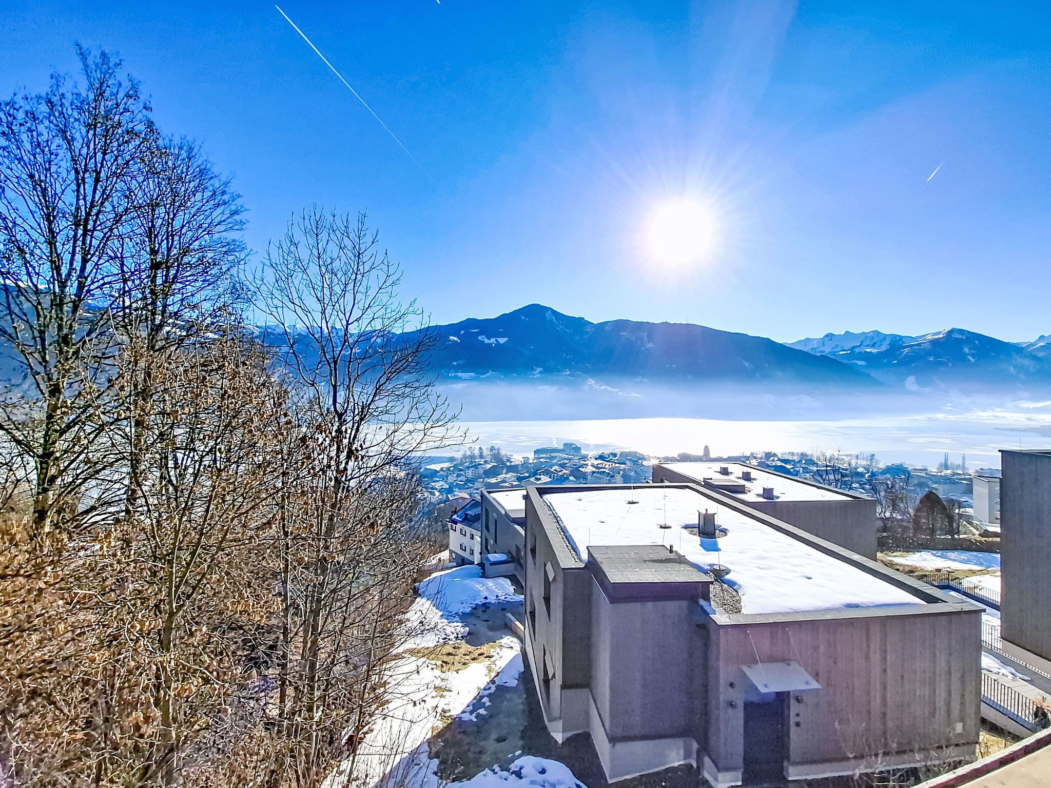 A building with a flat roof, surrounded by snow-covered ground and leafless trees.