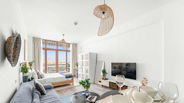 Ein modernes Wohnzimmer mit Sofa, Couchtisch und Essbereich mit weißen Tellern und Gläsern.