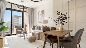 Een moderne woonkamer met een bank, salontafel en eettafel.