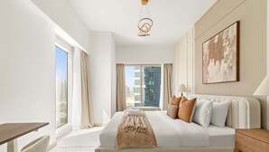 Ein modernes Hotelzimmer mit einem großen Bett, einem Schreibtisch und Blick auf die Stadt.