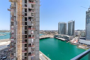 A high-rise building under construction with a view of a marina and modern buildings in the background. - Silkhaus Stylish Studio With Balcony 2 Min to Adgm in Al Maryah Vista (Abu Dhabi)