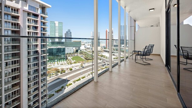 Un apartamento moderno con ventanas amplias, un balcón y vistas a la ciudad.