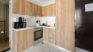 Eine moderne Küche mit Holzausstattung, einem Herd, einer Mikrowelle und einem Spülbecken.