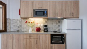 Una cucina moderna con mobili in legno, un forno a microonde, una macchina da caffè, un tostapane e un forno.