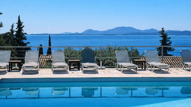 Area piscina con poltrona relax e vista mare e montagne.