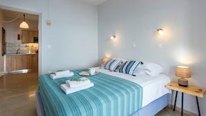 Una camera da letto con un letto, un comodino e vista sulla cucina.