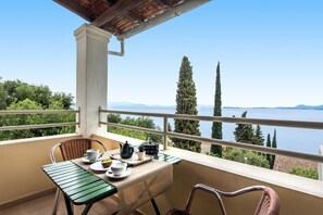 A balcony with a table set for tea, overlooking a lake and mountains. - Hotel Barbati - Poolside Gem With Sea Views (Corfu)
