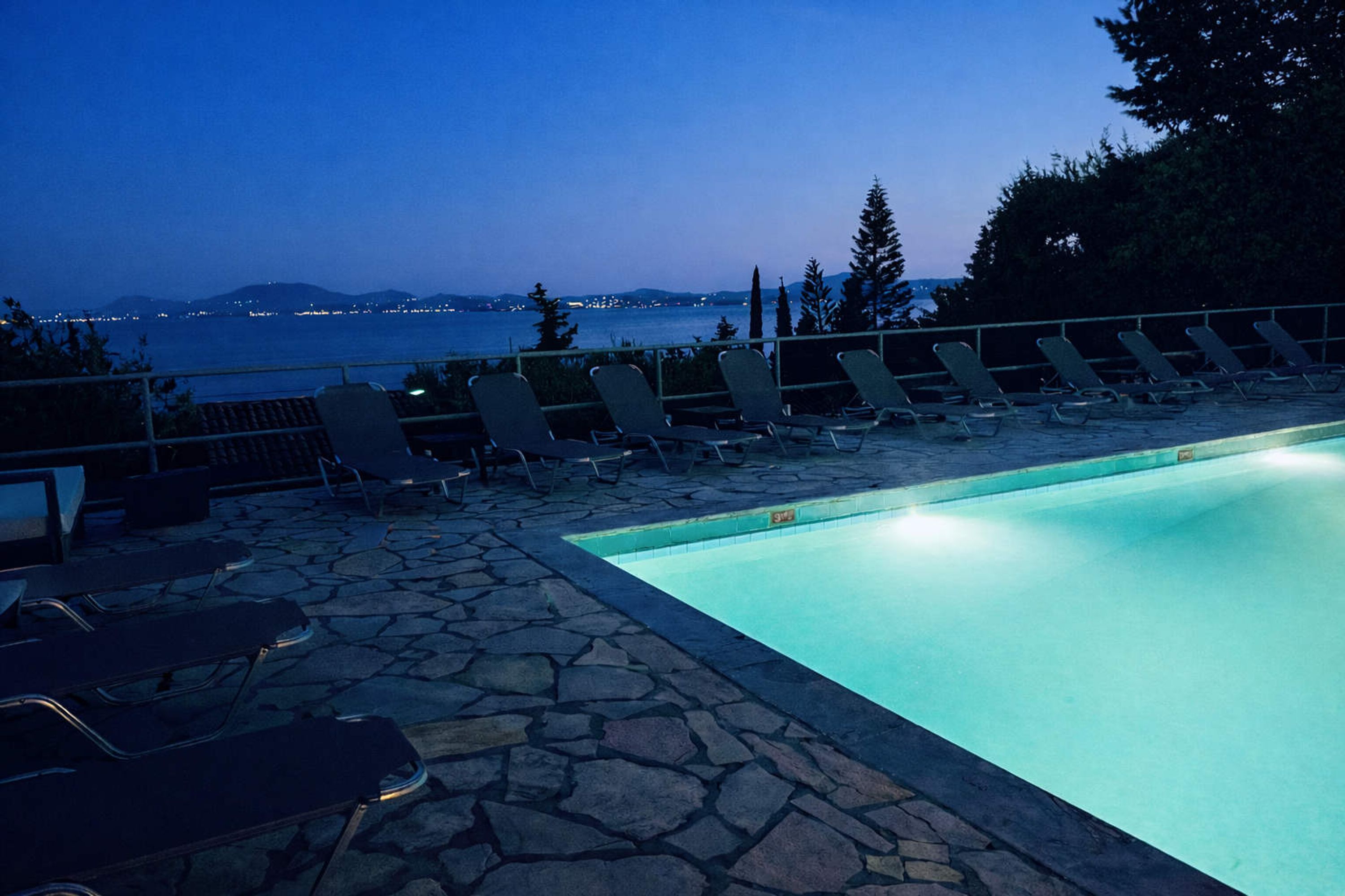 A poolside area with lounge chairs and a view of the water.