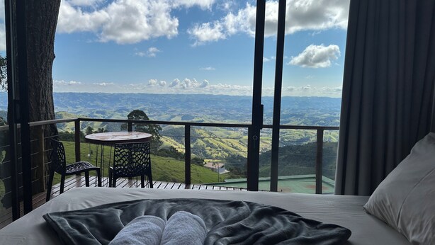 A balcony with a table and chairs, overlooking a scenic landscape. - Pousada Dona Pedra (Córrego do Bom Jesus)