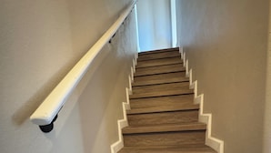 A staircase with wooden steps and white handrails.