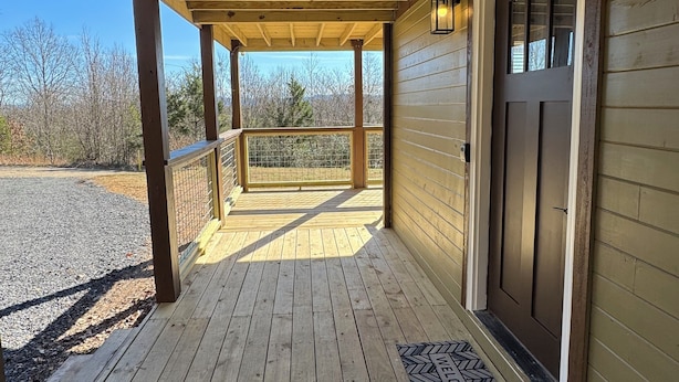 A wooden porch with a view of the surrounding landscape.