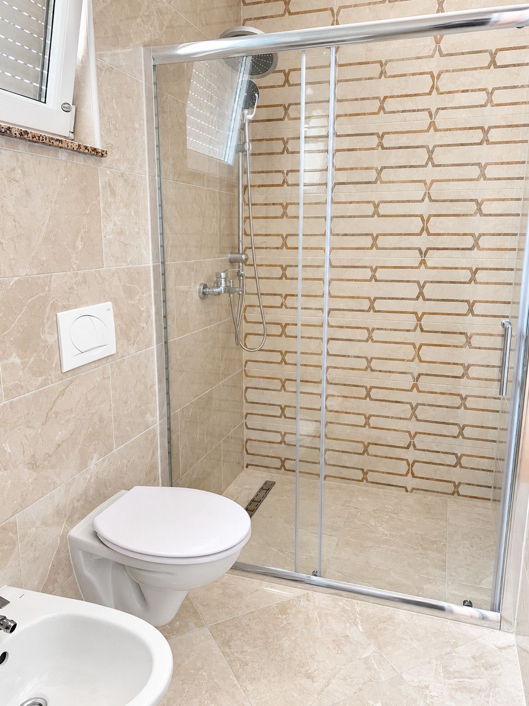 A modern bathroom with a glass-enclosed shower, a toilet, and a sink.