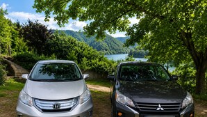 Two cars parked on a dirt path with a scenic view of a lake and forest in the background. - Guesthouse Noestan (Acharistskali)
