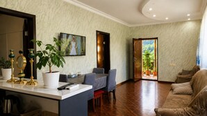 Una sala de estar con comedor, televisión y vistas al exterior.