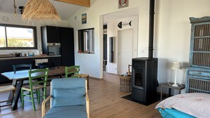 Una sala de estar acogedora con chimenea, un comedor con mobiliario de madera y una cocina con electrodomésticos modernos.
