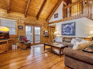 A wooden interior with a fireplace, a sofa, a television, and a dining table. - 8 minutes from Pigeon Forge Tn/ Hot Tub/Jacuzzi Tub/ Wifi (Sevierville)