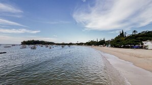 A beach with calm waters, a sandy shore, and a small island in the distance. - Casa p 5 Pessoas Perto das Praias e Beto Carrero (Penha)